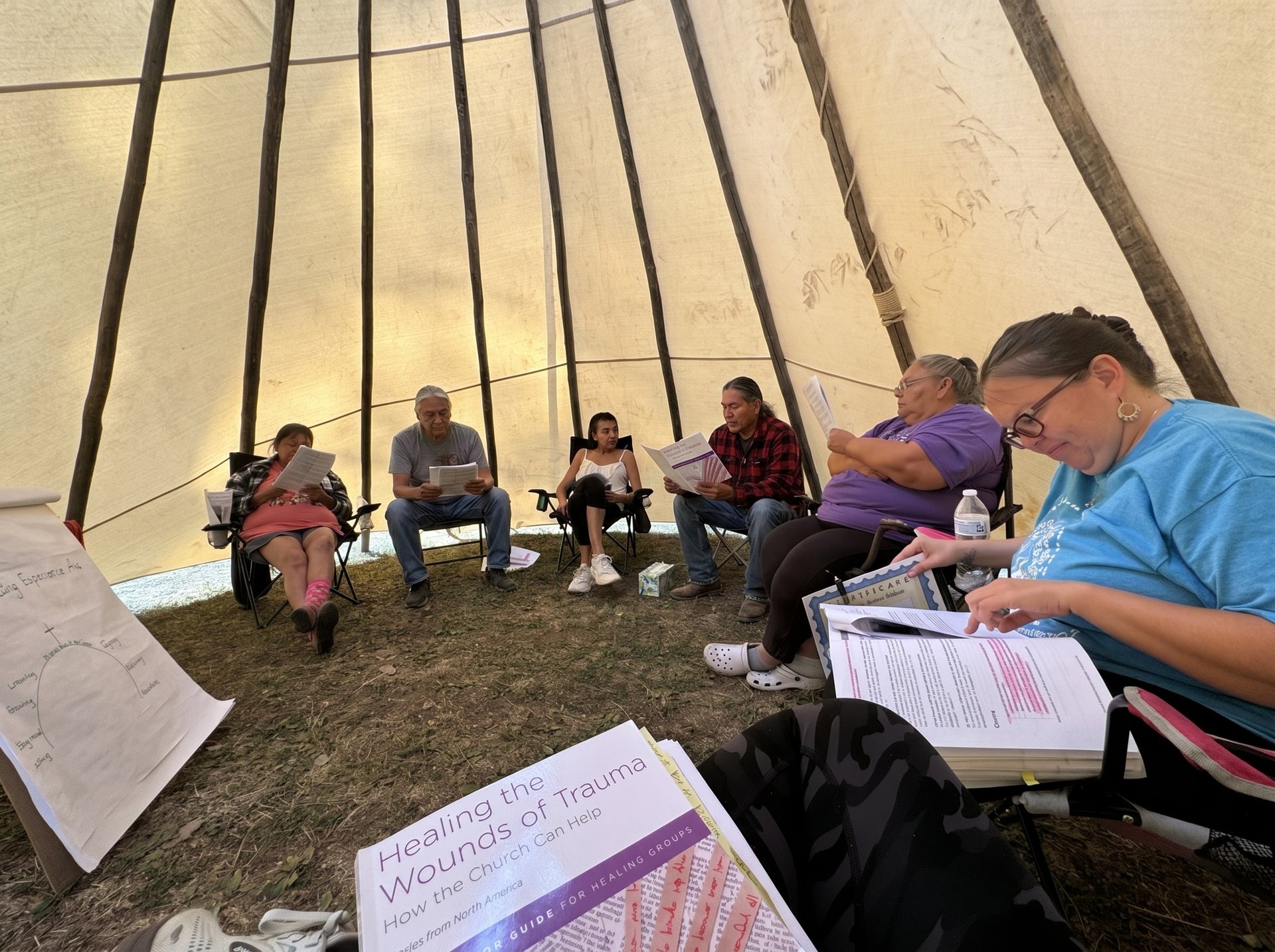 Participants gathered in a circle inside a tipi at a healing retreat